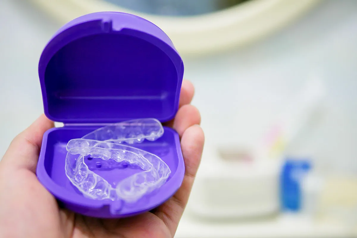 Clear dental trays in a purple storage case