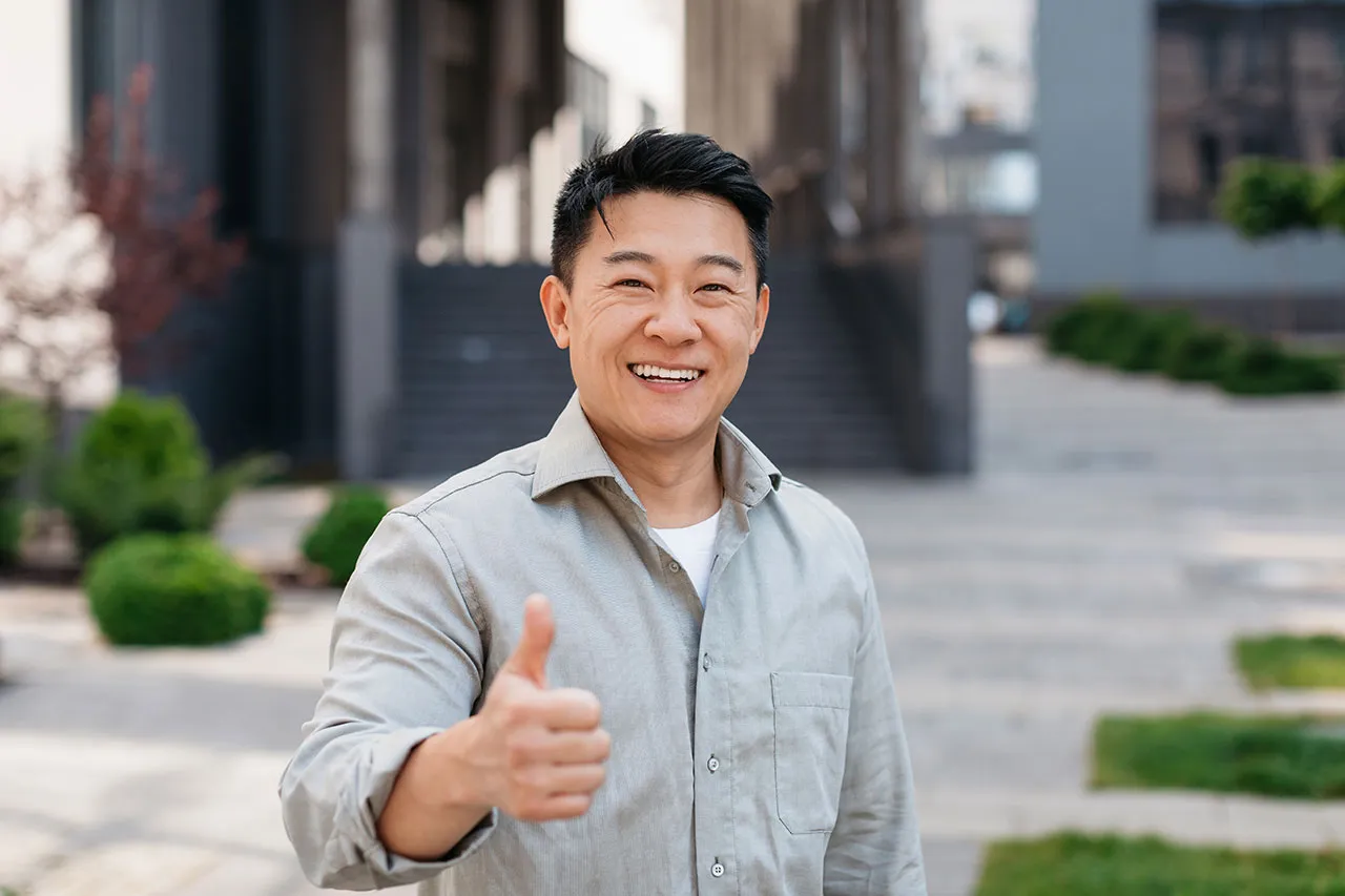 Man smiling and giving a thumbs up